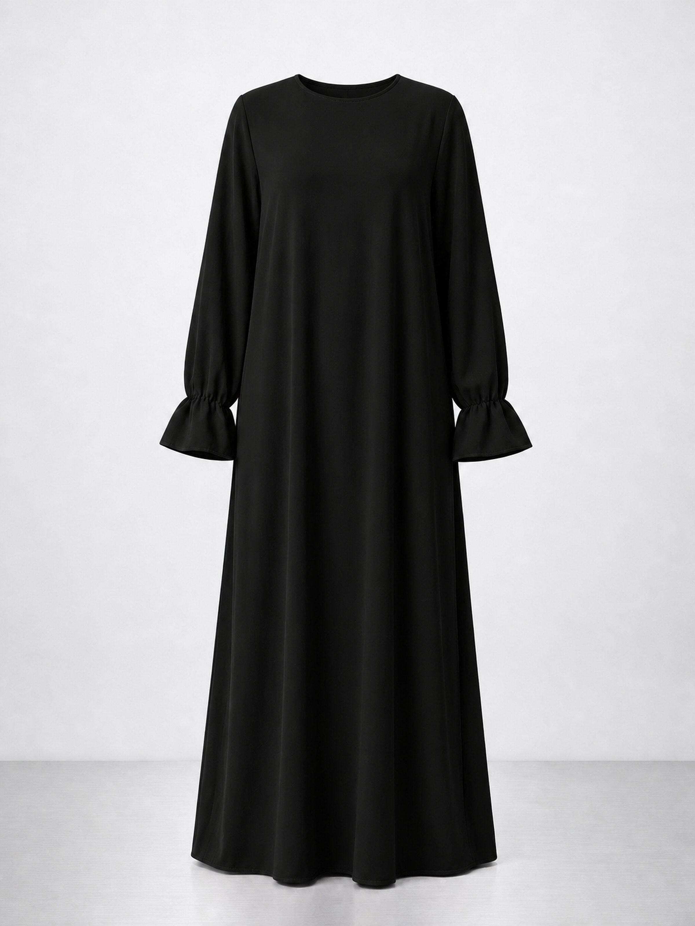 Abaya noire à poignets volantés sur fond studio blanc