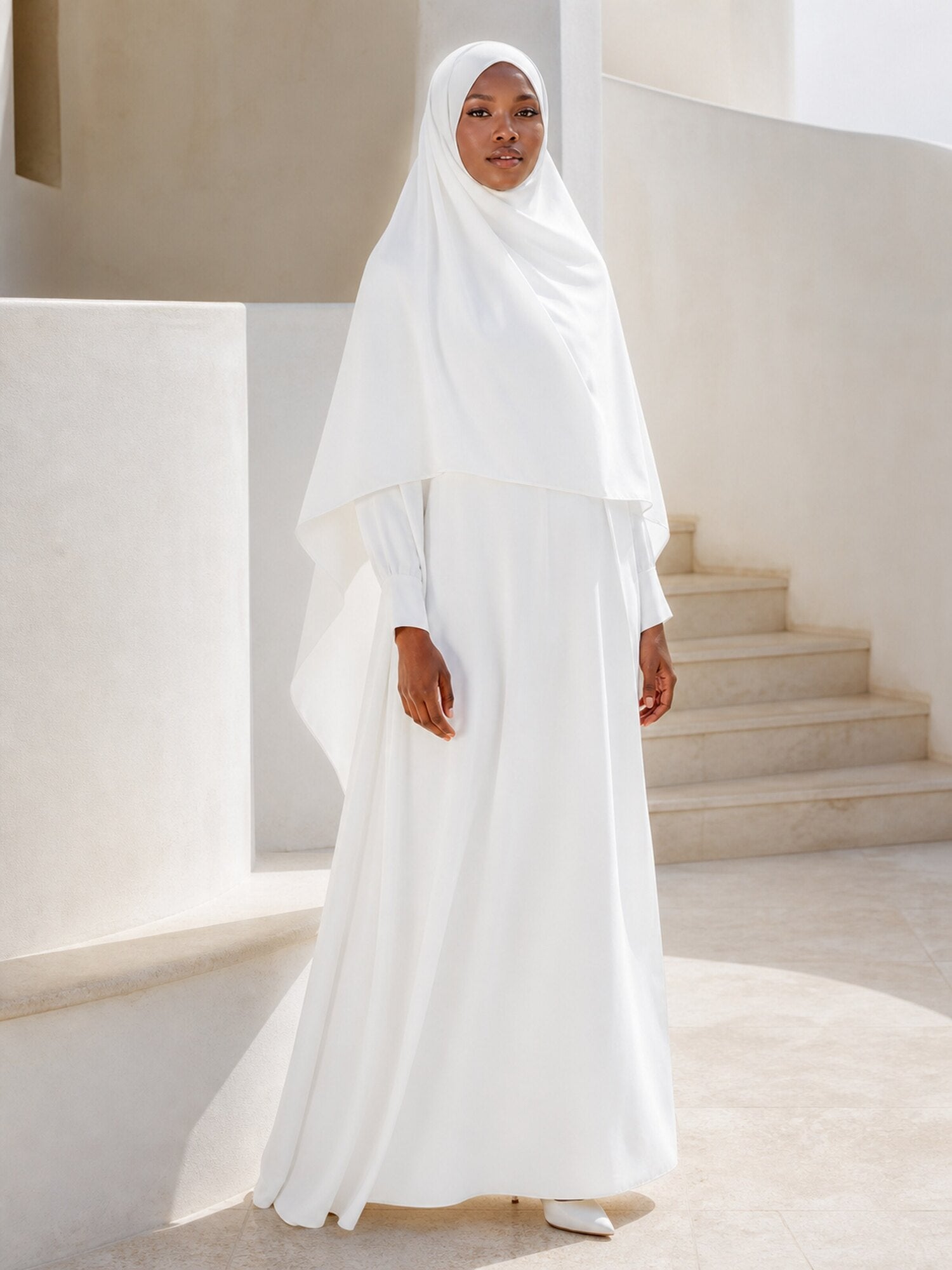 Femme portant un khimar blanc dans une architecture lumineuse